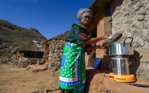 Woman in a rural village using ACE stove – African Clean Energy (ACE)