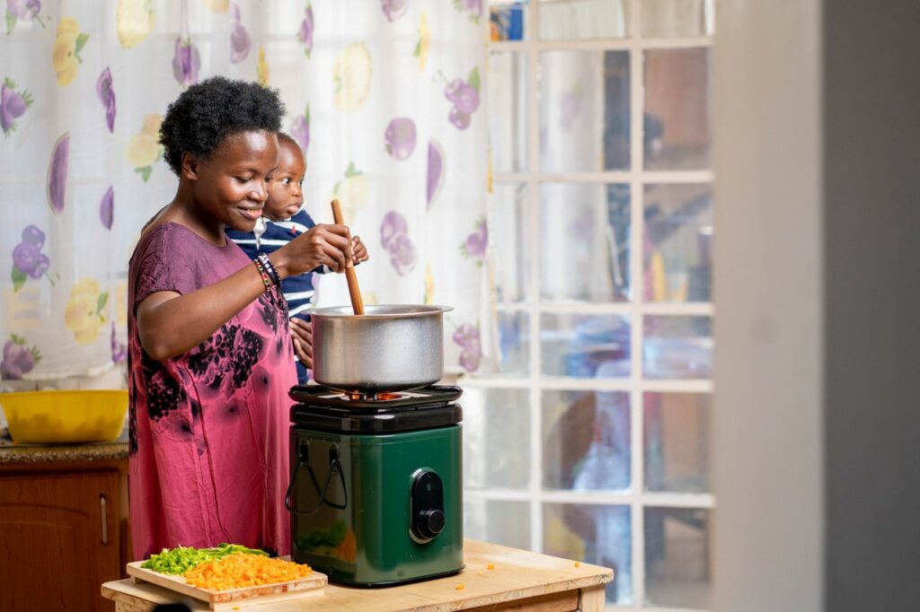 Photo: Woman with her baby cooking food on a BetterStove – EcoSafi